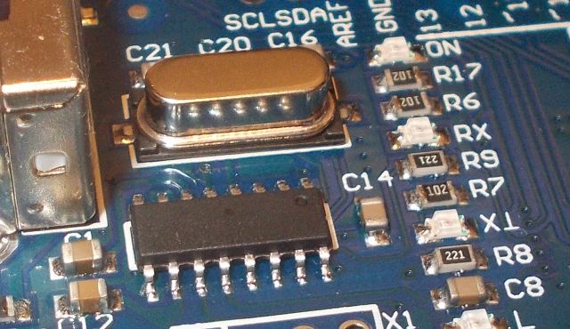 Hamisított USB illesztő chipek: a technológiai csalás új szintje - Cseh Robert / TavIR Egy elektronikai áramkör közelképe, amelyen kvarckristály, ellenállások, kondenzátorok és egy ismeretlen felirat nélküli chip látható (hamis CH340)