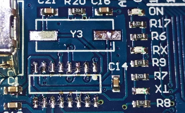 Hamisított USB illesztő chipek: a technológiai csalás új szintje - Cseh Robert / TavIR Kiforrasztott USB-illesztő chip helye egy nyomtatott áramköri lapon, ahol a forrasztási pontok, a „Y3” jelzésű kvarc pozíciója, valamint ellenállások és kondenzátorok kapcsolódása látható.