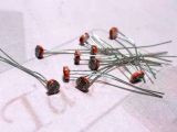 Fényérzékelés fotoellenállással - Cseh Robert / TavIR Egy halom kis elektronikai alkatrész, fotoellenállások (LDR - Light Dependent Resistors), amelyek két hosszú, vékony fém lábbal rendelkeznek, és egy kis, kerek, bordázott felülettel ellátott fejrésszel rendelkeznek.